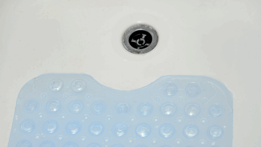 Blue non-slip bath mat with raised texture on a bathroom floor