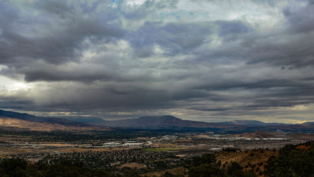 Cloudy sky above a wide valley surrounded by mountains