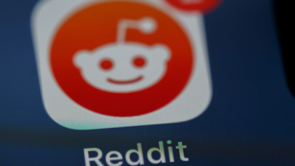 Red and white Reddit logo displayed on a dark background