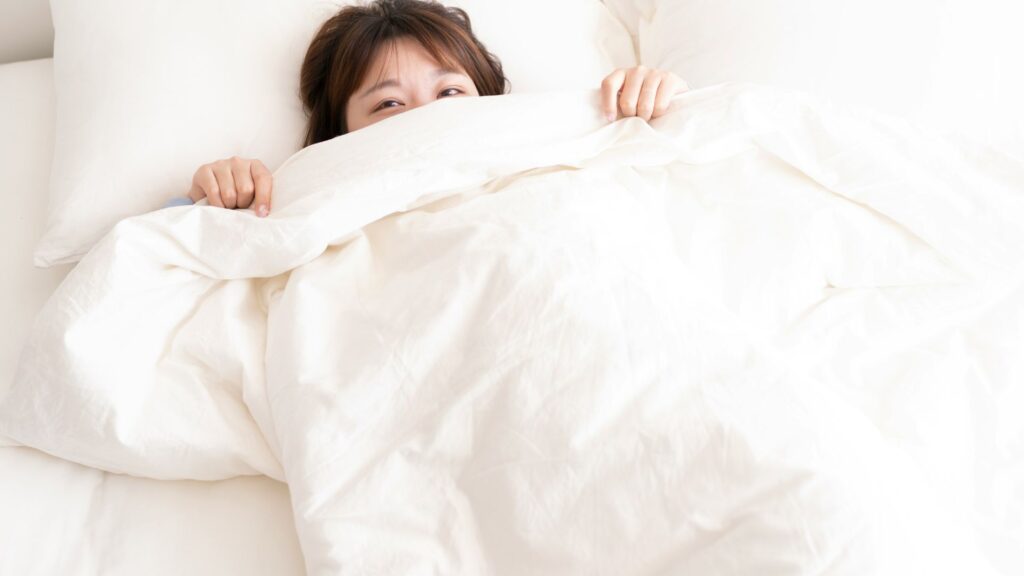Woman lying in bed with morning light filling the room
