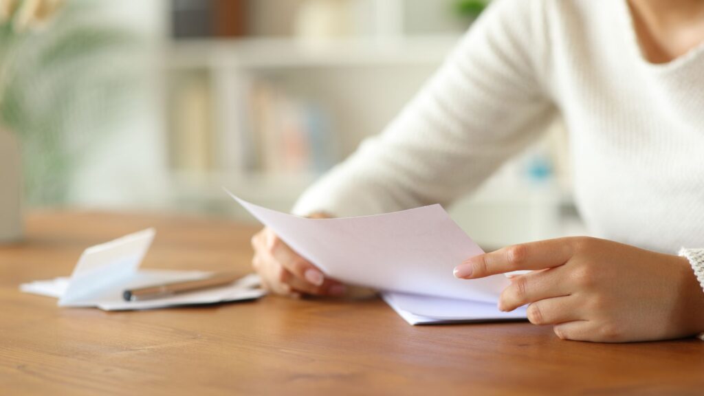 Woman holding and reading a letter with both hands