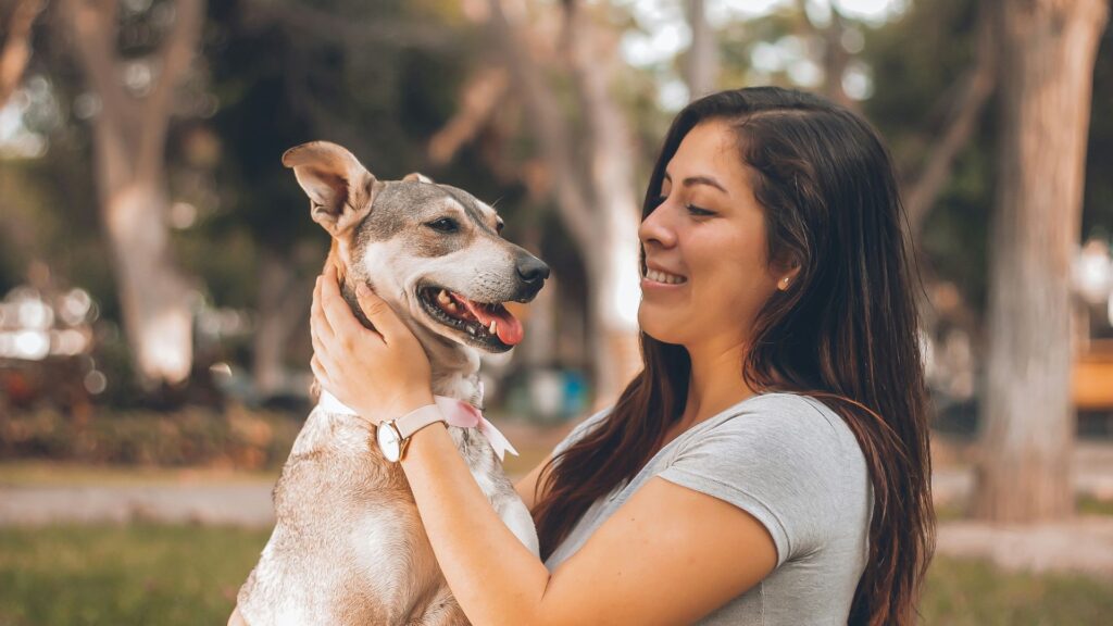 Woman playing with her dog in an outdoor setting